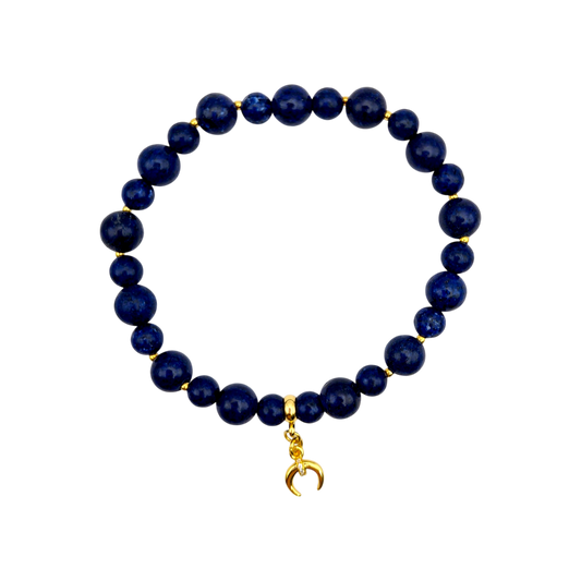 Elegantes Lapislazuli-Armband mit vergoldetem Mondanhänger und goldenen Zwischenelementen auf elastischem Band.

